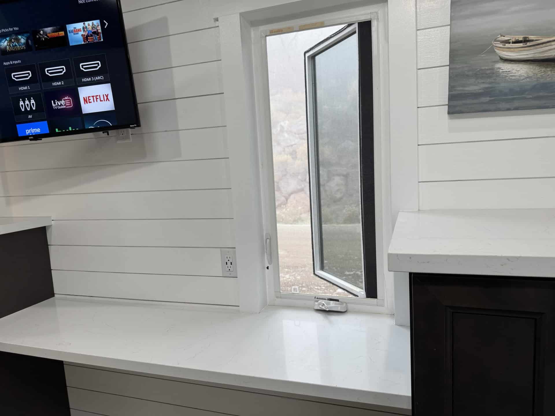Modern tiny house interior with Smart TV, shiplap walls, and quartz counters