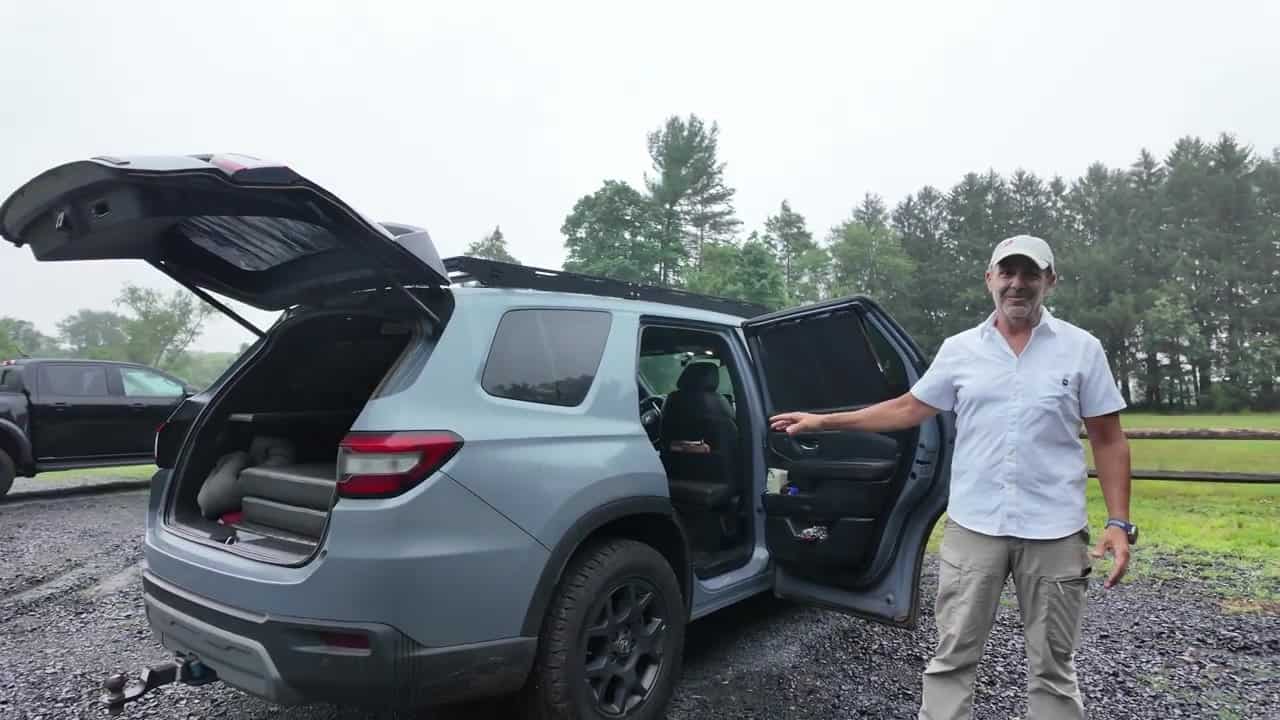 2024 Honda Pilot TrailSport conversion with black roof rack, rear hatch and passenger door open, Aaron presenting the build on a gravel lot