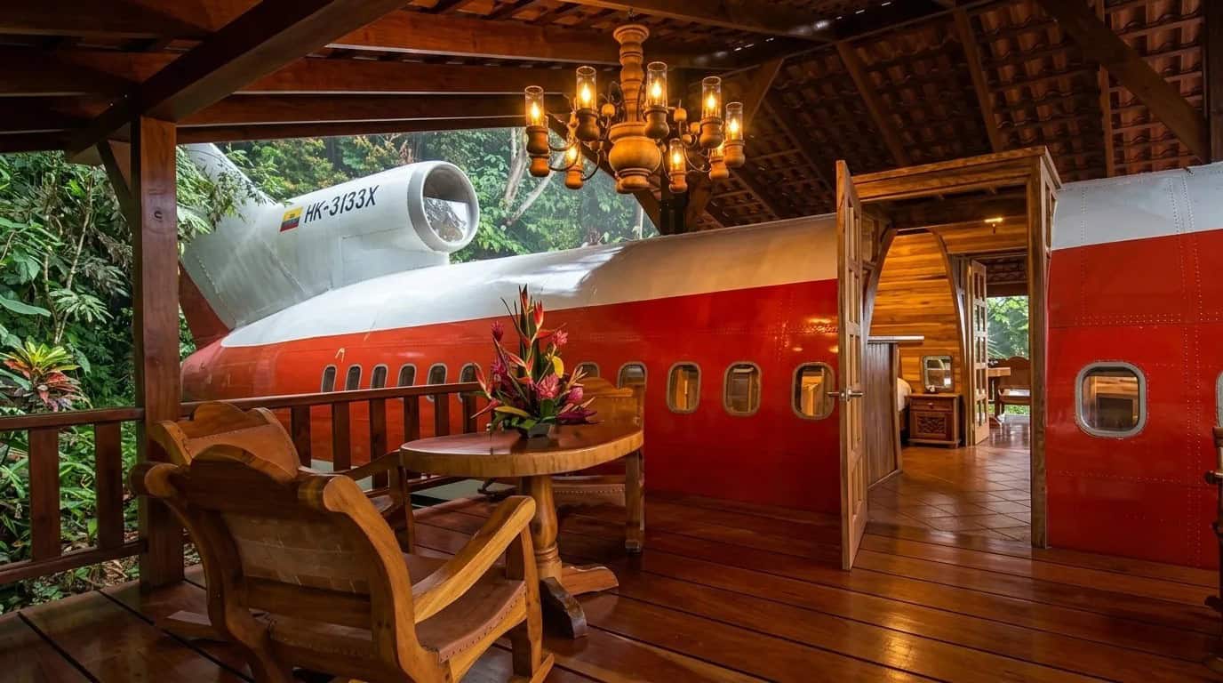 Polished wooden deck and chandelier leading into the open doorway of the 727 fuselage suite