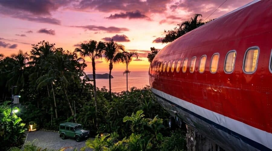 Boeing 727 fuselage suite on a stone pedestal over jungle canopy at sunset, Manuel Antonio ocean beyond, Hotel Costa Verde