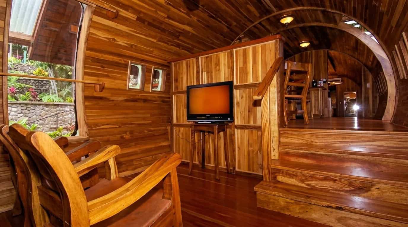 Carved wooden rocking chair, flat-screen TV, and wooden steps inside the curved 727 fuselage