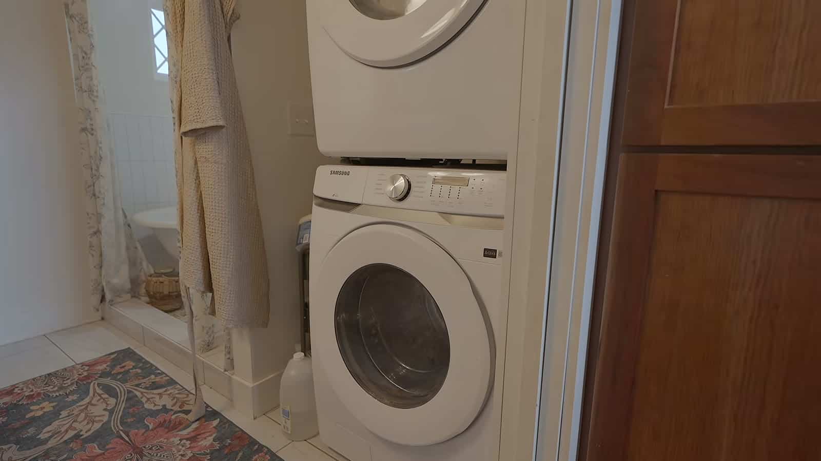 Stacked front-load washer and dryer inside the downstairs bathroom