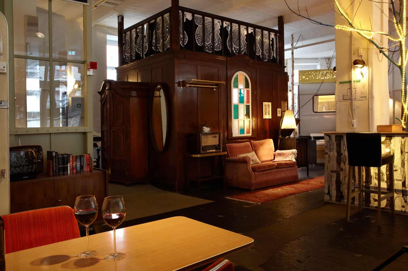 Alter Palast wooden hut interior-hall exterior: dark wood, stained-glass window, pink sofa