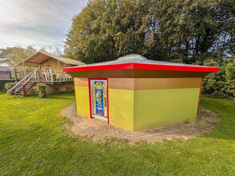 UFO Spaceship cabin on the lawn at Jan Klaassen Dromenland: bronze and lime faceted saucer with red-rim roof