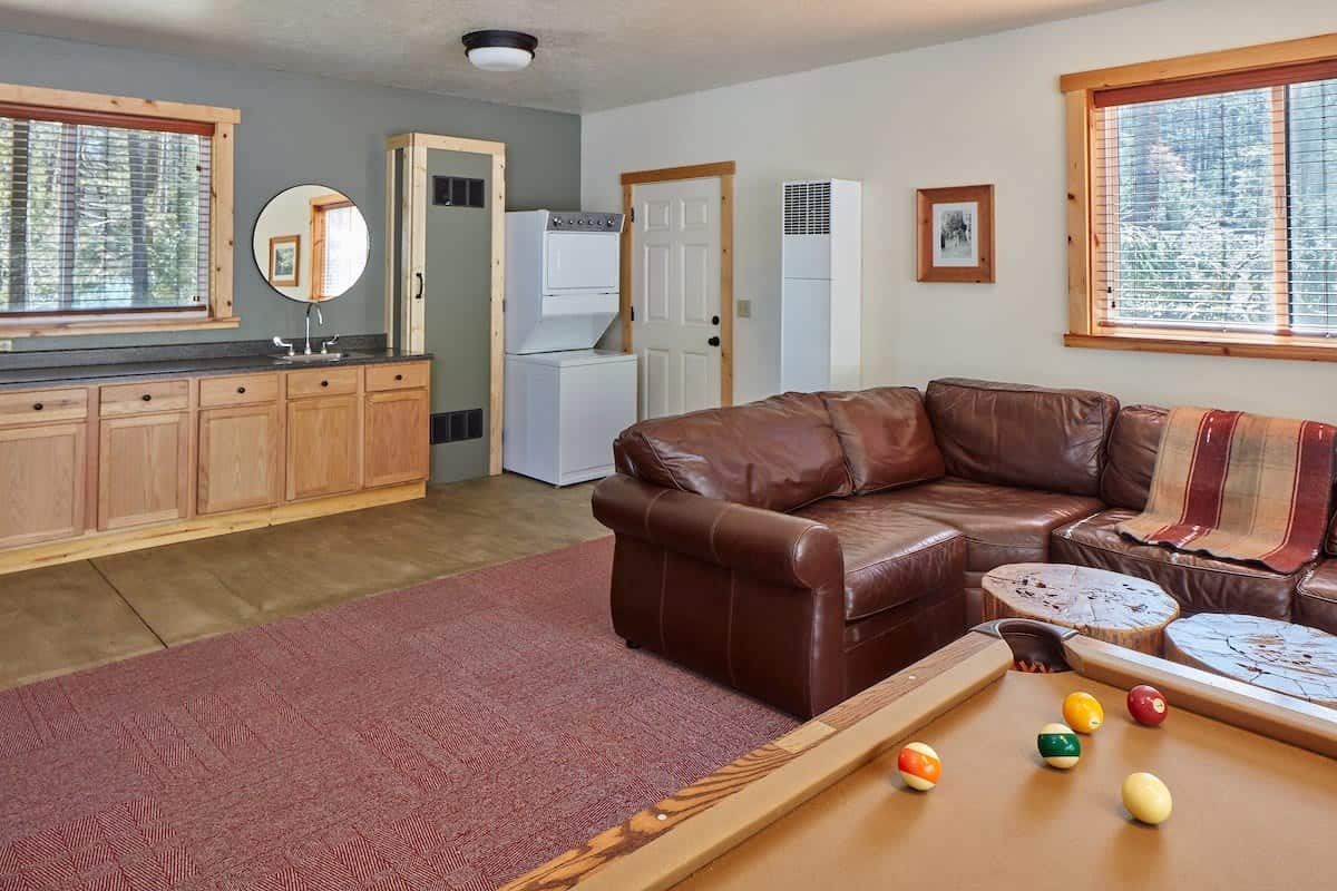Leather sectional sofa in the game room with a counter, sink, and stacked washer and dryer