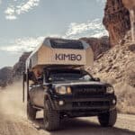 Off-grid tiny house mounted on a truck in a desert canyon landscape.
