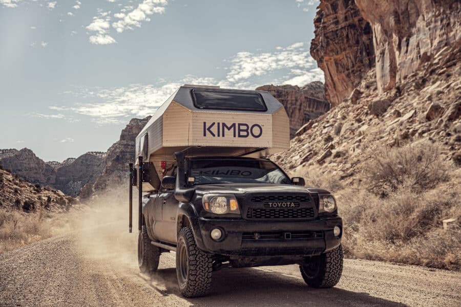 Off-grid tiny house mounted on a truck in a desert canyon landscape.