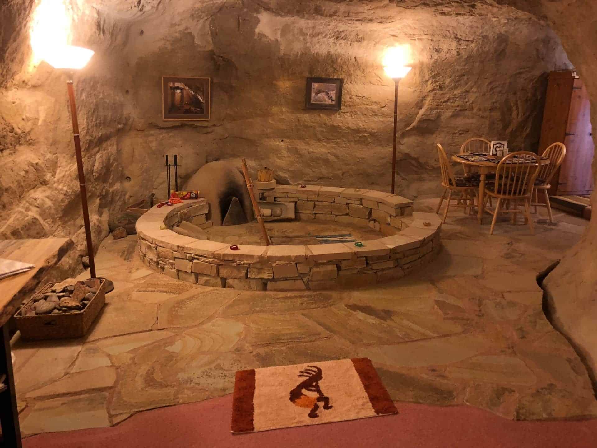 Replica Native American kiva: circular stacked-stone ring, dining set in a sandstone alcove