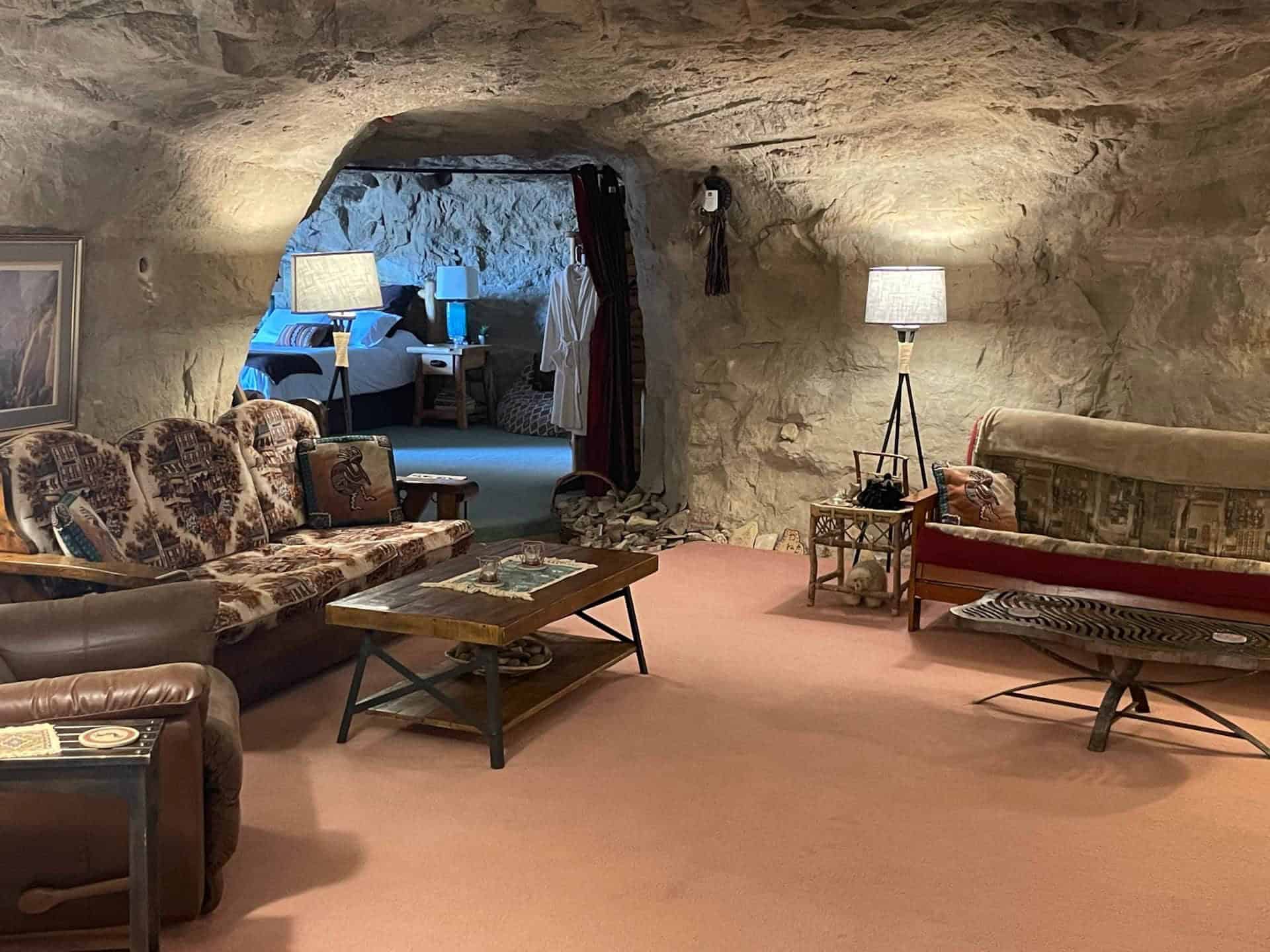 Sitting room with sofas and a rock-arch opening toward the bedroom