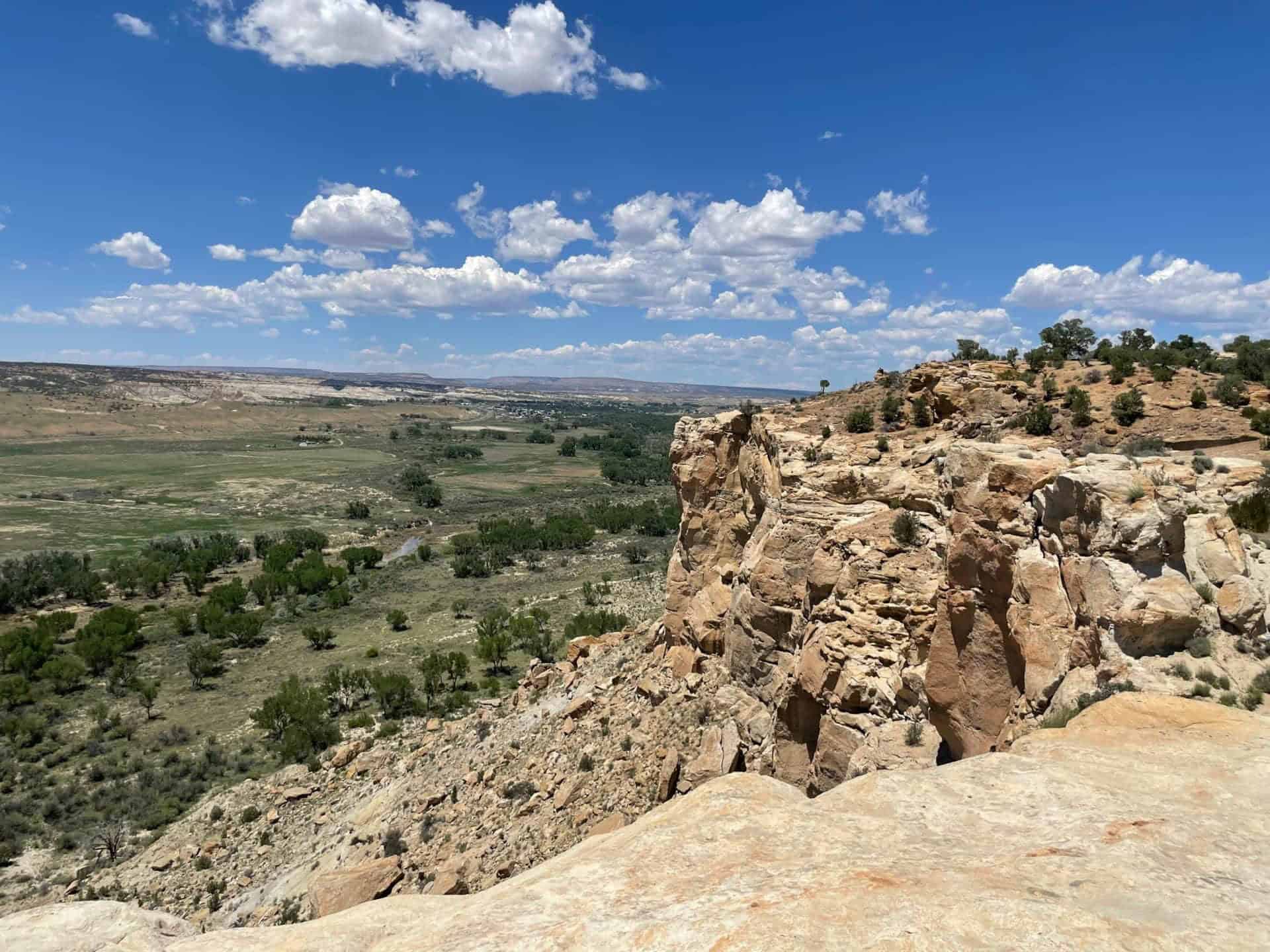 View from the parking area: river valley and mesas below a sandstone cliff, Farmington New Mexico