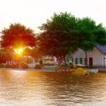 Sunset over the pond, community homes, and pool at Liberty Tiny Village in Aubrey, Texas