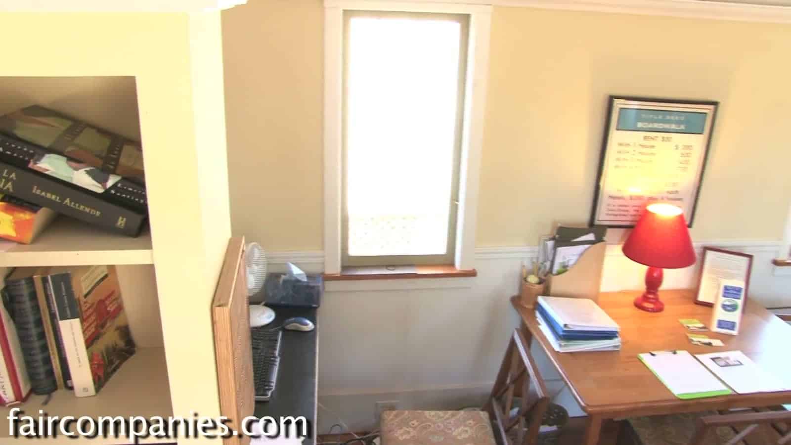 Writing desk with a red lamp under a window inside the Little House on a Trailer