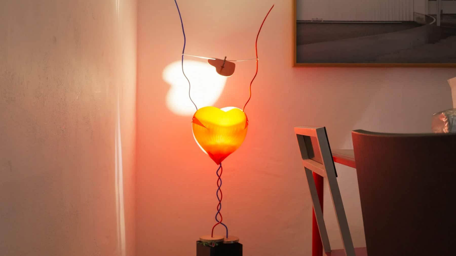 Glowing red heart-shaped lamp on the dining table