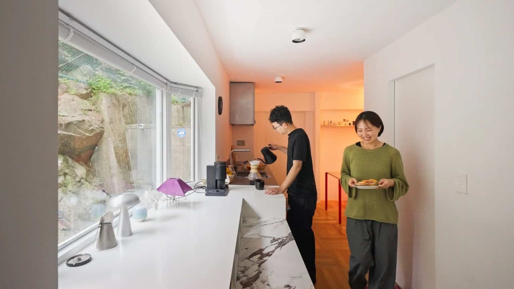 Couple making coffee and breakfast at the bar by the rock wall window