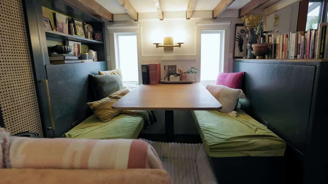 Built-in diner booth that seats four with lime-green cushions, a wood pedestal table, and a white dog bed underneath