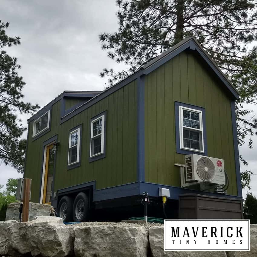 Maverick Quantum gallery exterior: olive board-and-batten, dark trim, glass side door, mini-split condenser on the end wall, dual-axle trailer