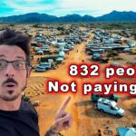 Large RV parking lot in desert with 832 people living rent-free in RVs.