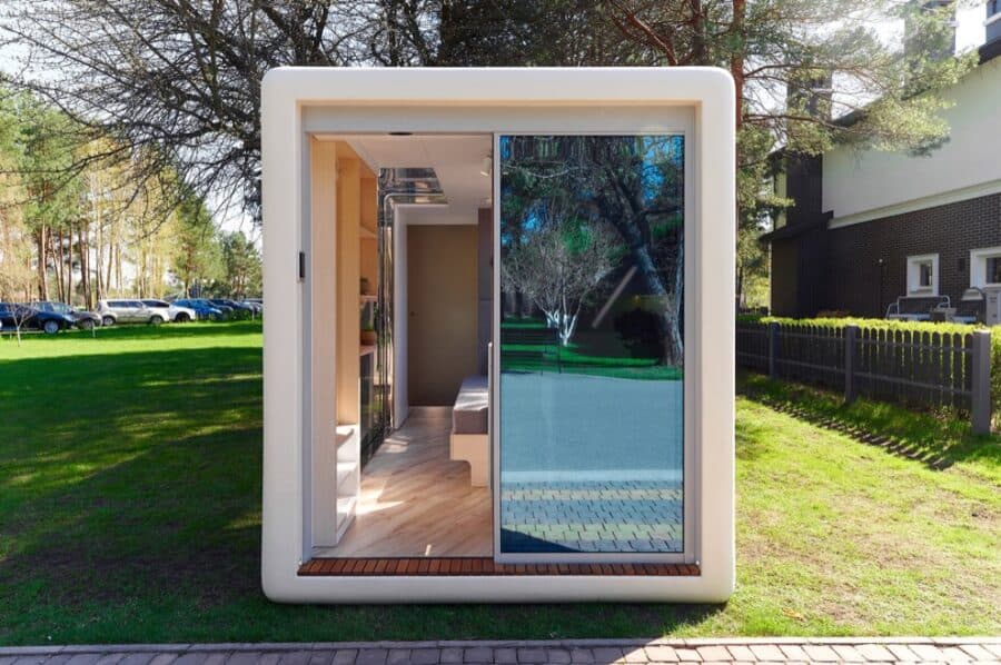 Compact modern tiny house with large glass door.
