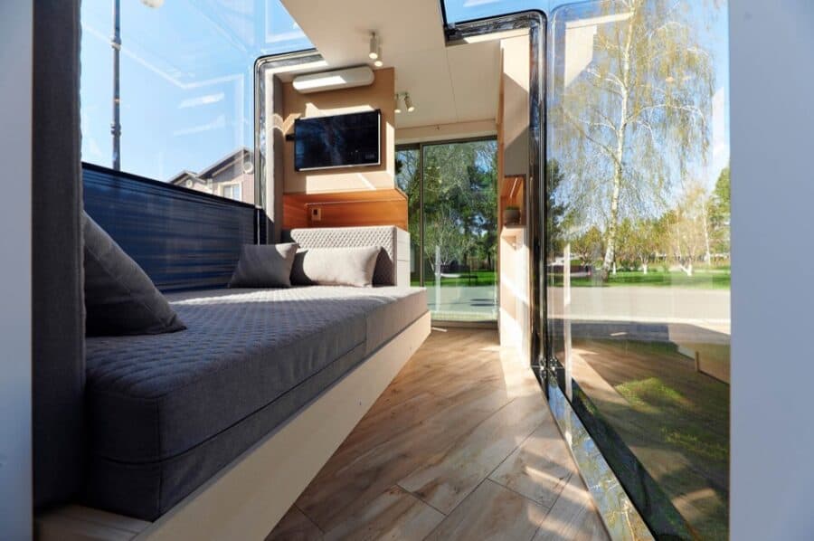 Compact tiny house interior with large windows and modern design.