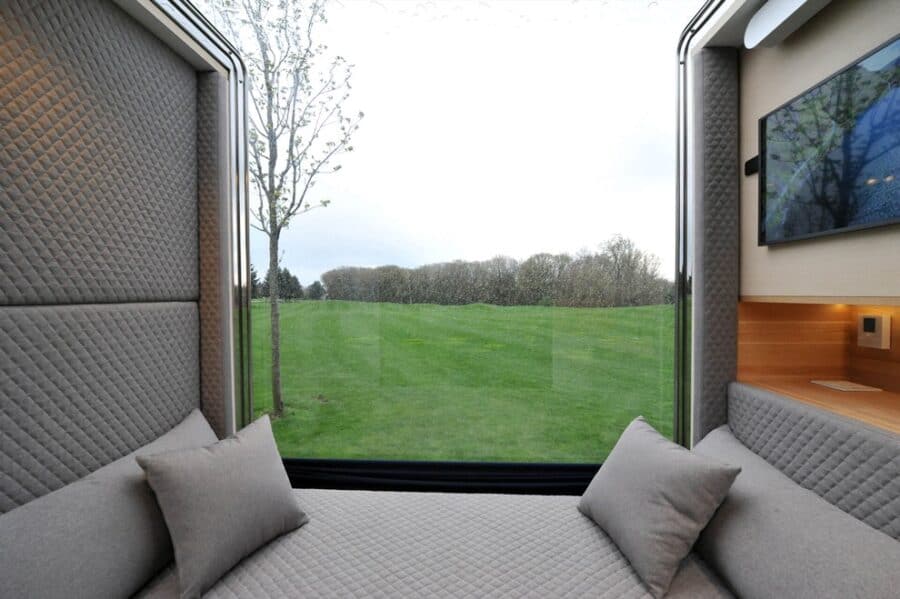 Compact microhouse interior with large window and cozy seating area.