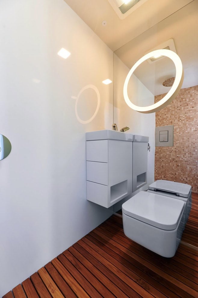 Modern tiny house bathroom with sleek fixtures and wooden flooring.