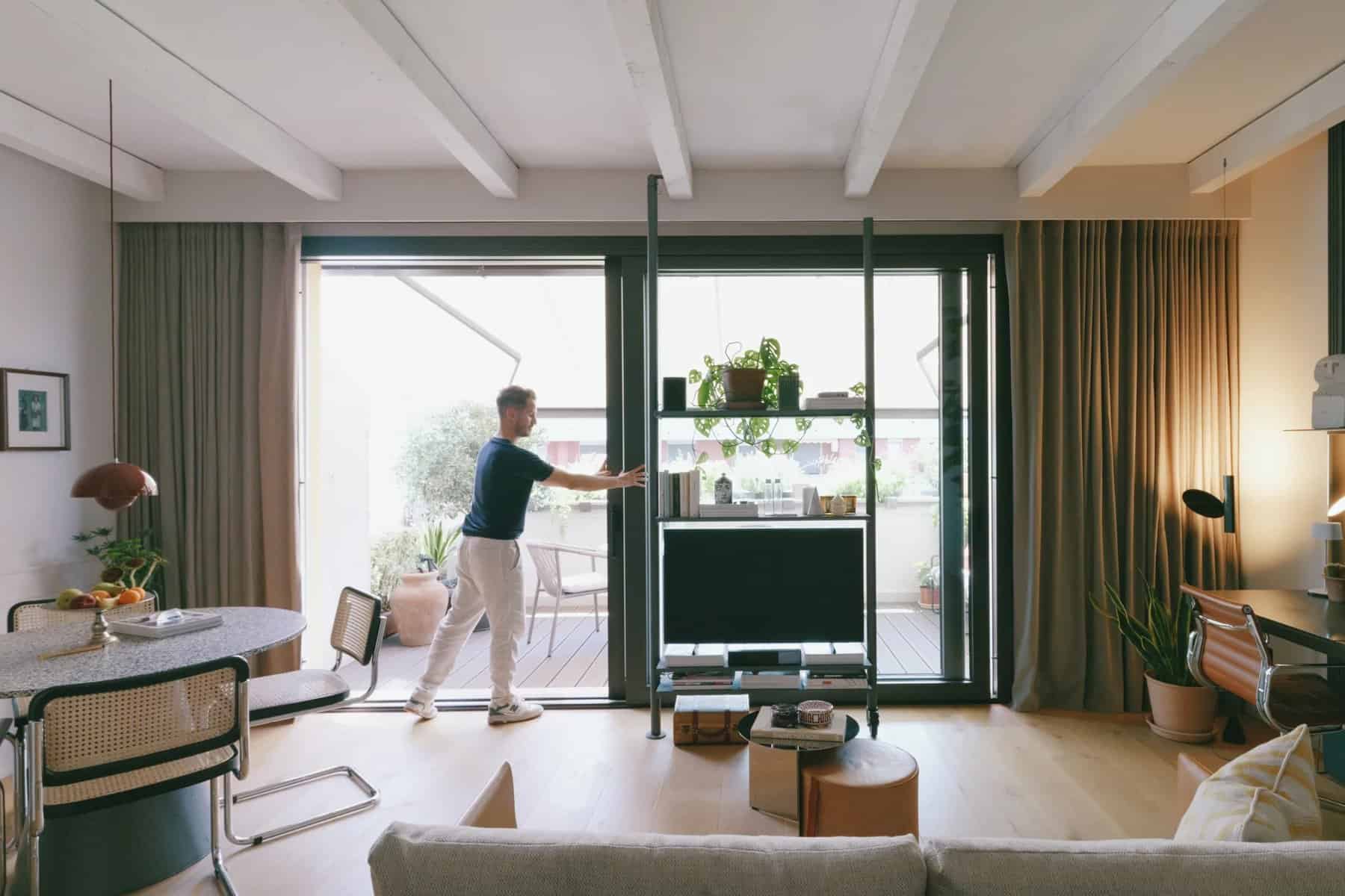 Living room opening through full-height sliding glass doors onto the terrace