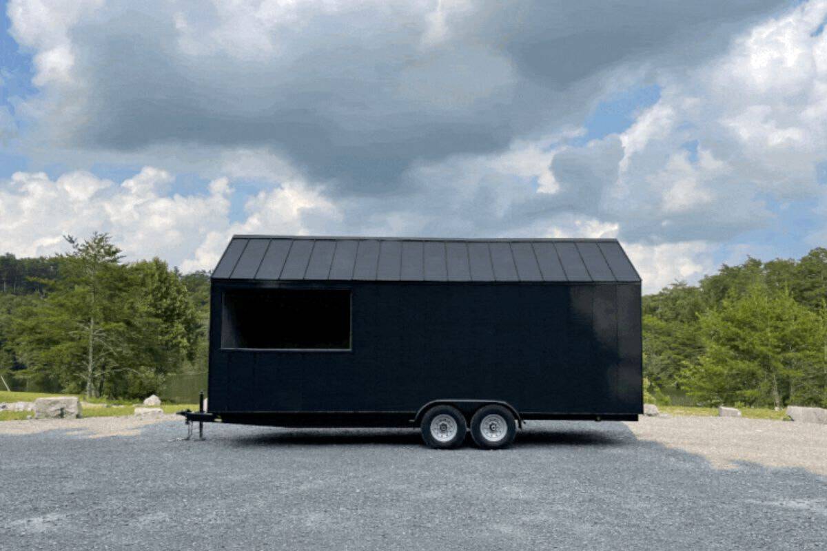 Side profile of the Minimalist black tiny house on wheels with picture window