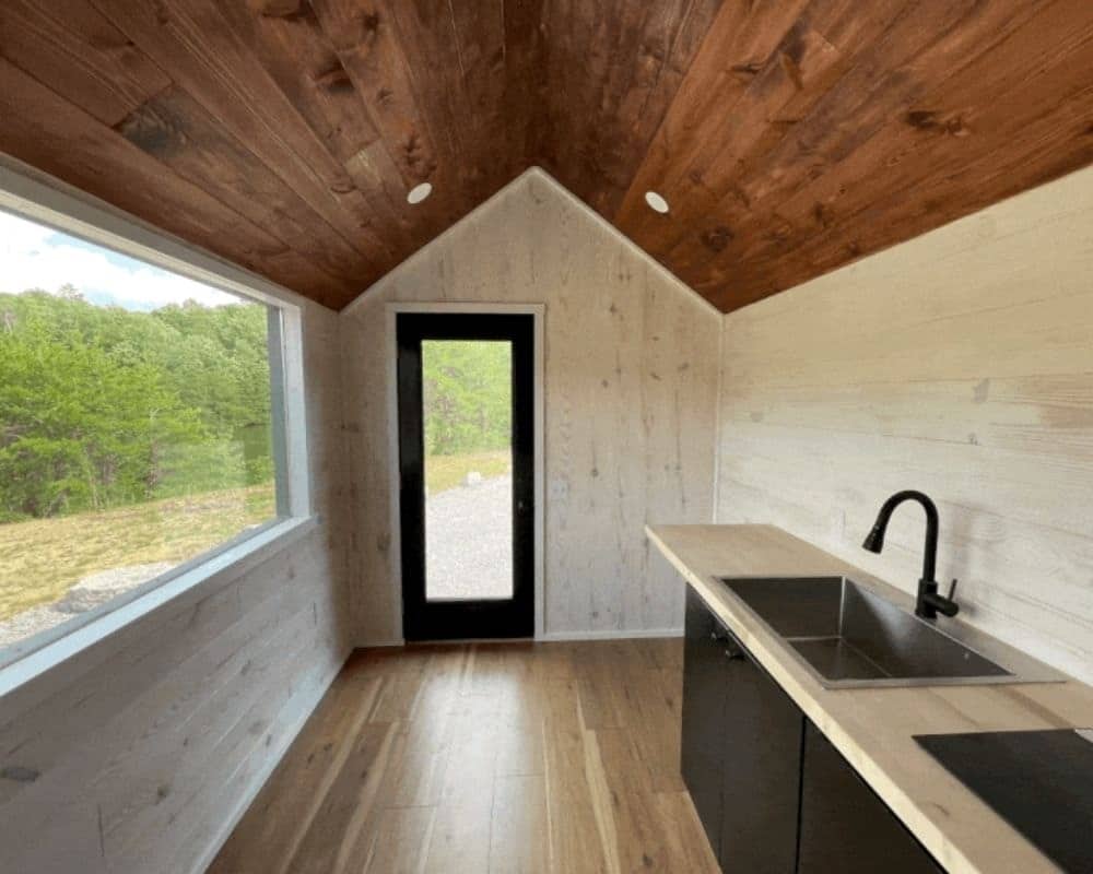 Bright open interior of the Minimalist tiny house with vaulted wood ceiling
