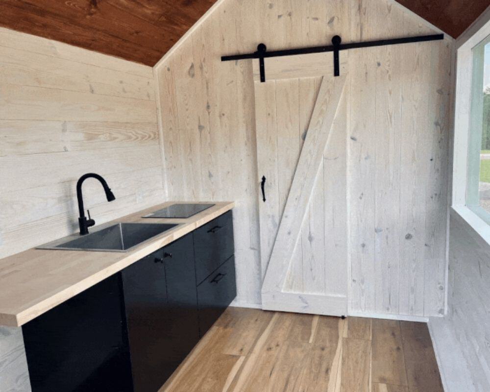 Black and butcher block kitchenette with induction cooktop in the Minimalist tiny house