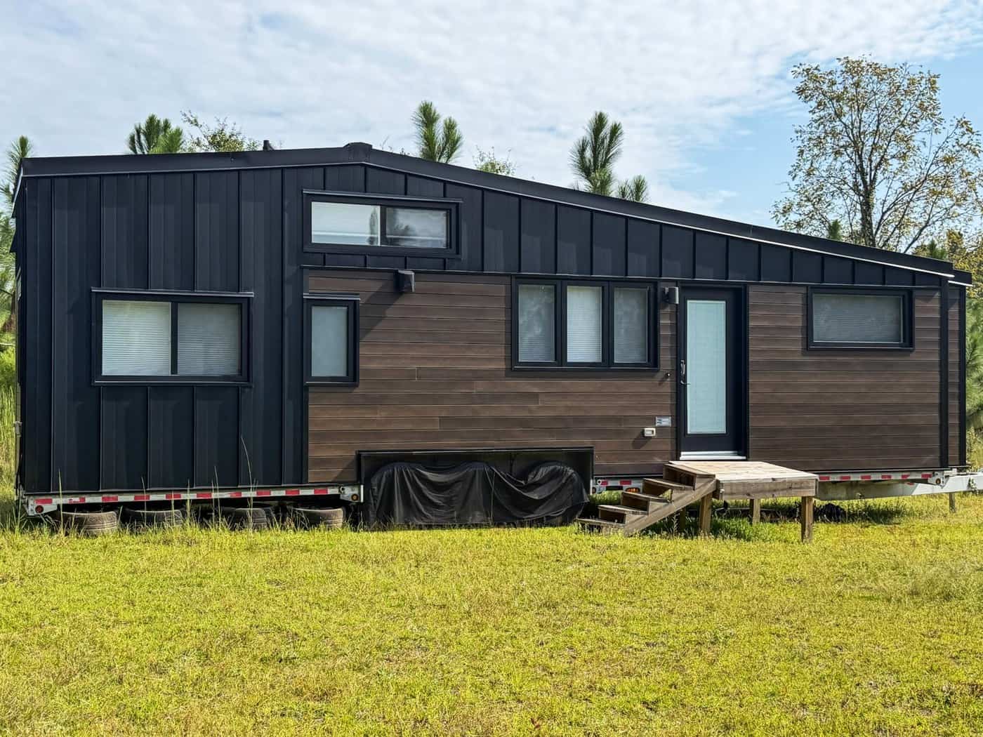 Side view of the dark Minimaliste tiny house showing board and batten and wood siding