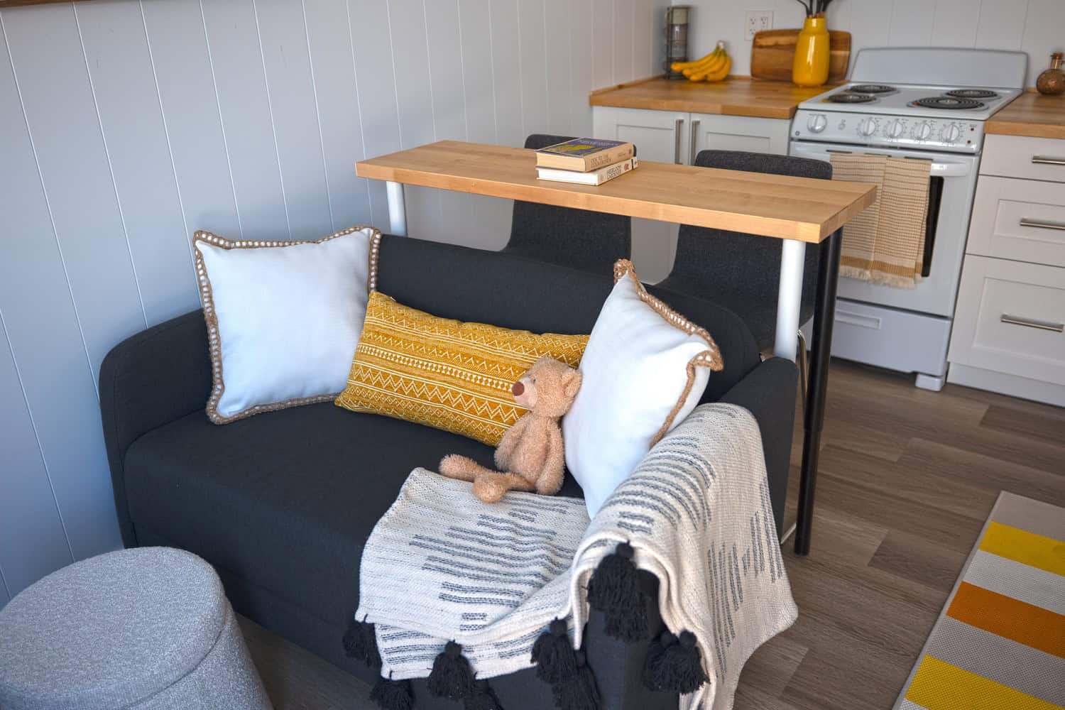 Jason living area: white paneling, grey seating, butcher-block, light vinyl in the Paris color scheme