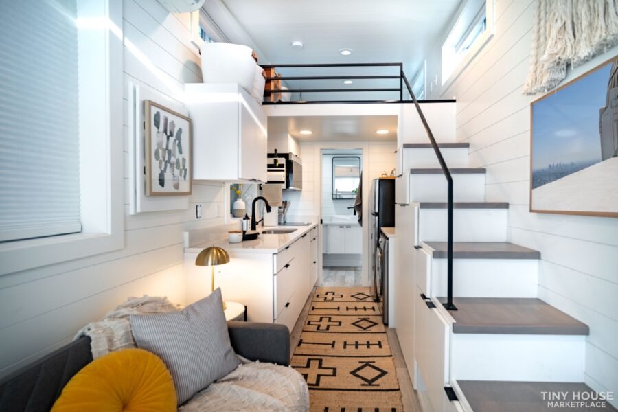 Compact shipping container tiny house with efficient kitchen and cozy living space.