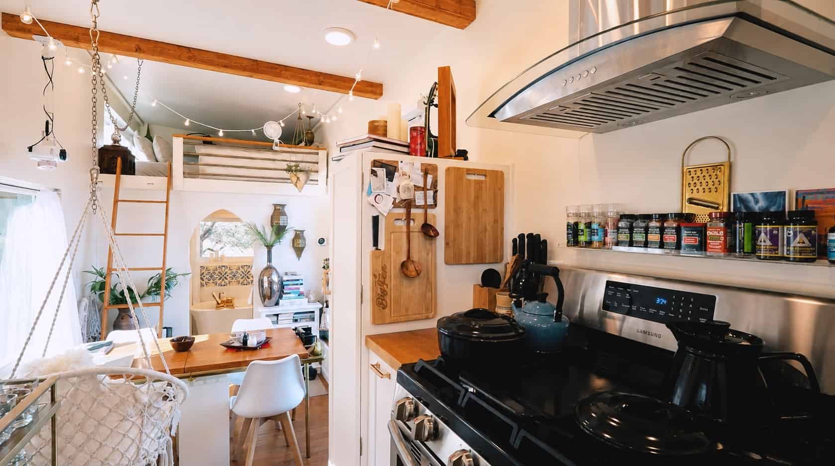 Bright boho interior of the Moroccan inspired tiny house with loft and swing chairs