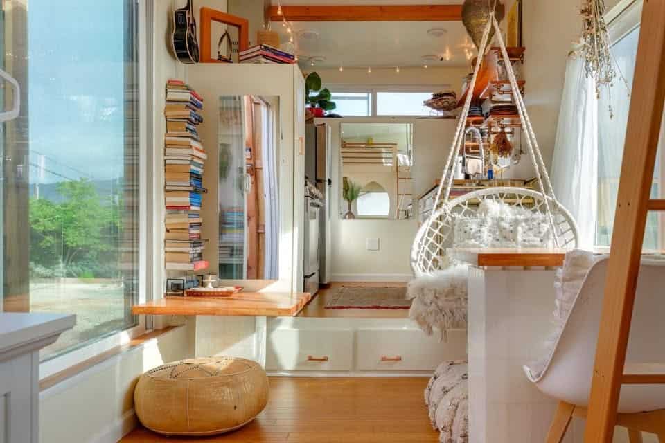 Living and dining area with fold down table, book wall, and Moroccan poufs