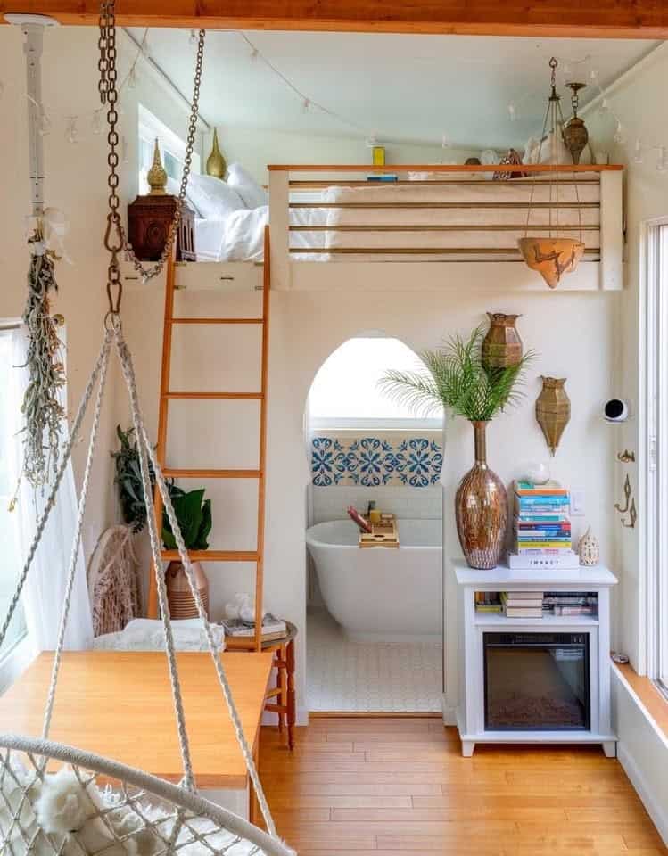 Sleeping loft with queen bed above the archway bathroom in the Moroccan tiny house