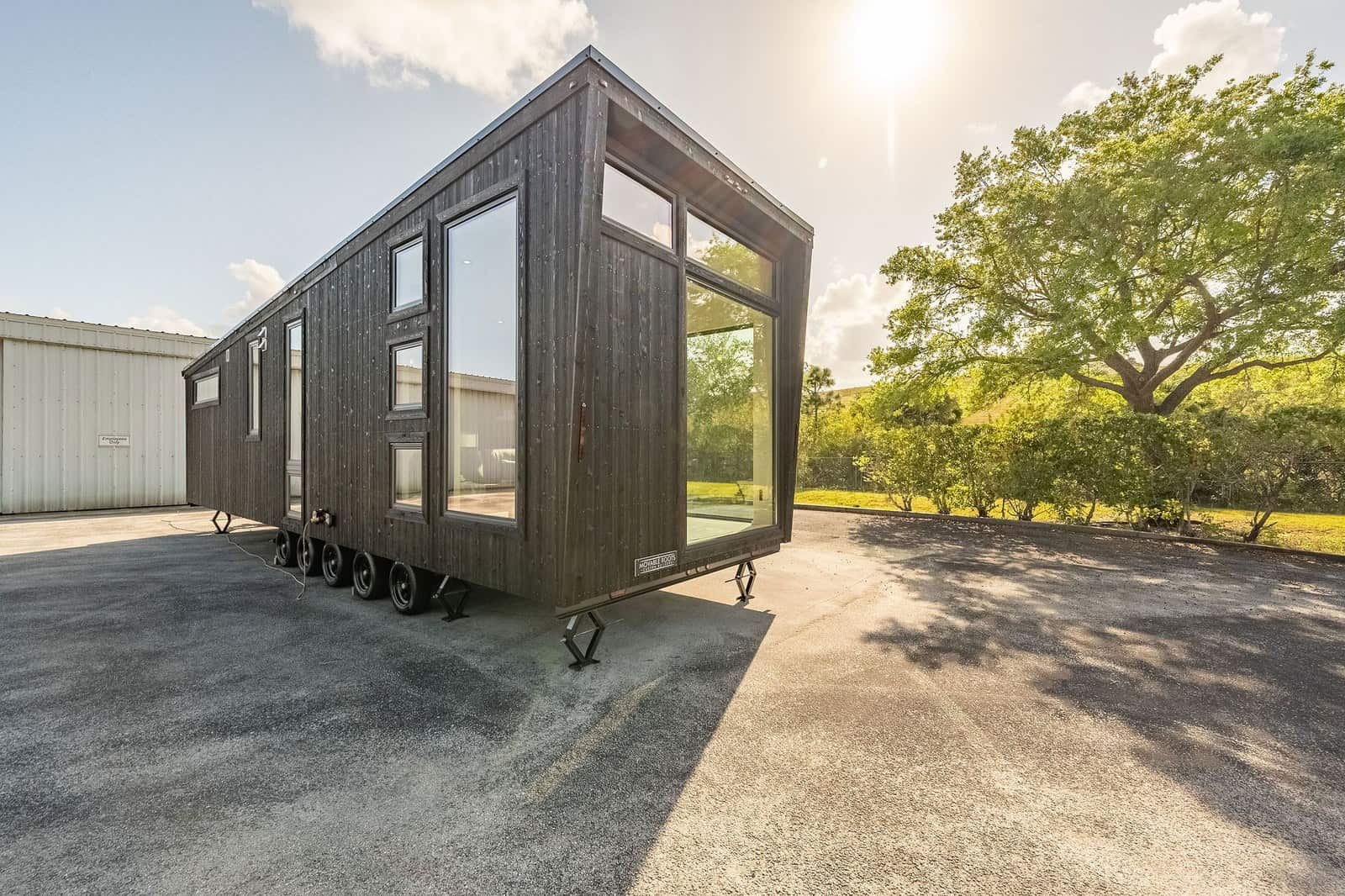 Modern tiny house on wheels with large windows built by Movable Roots