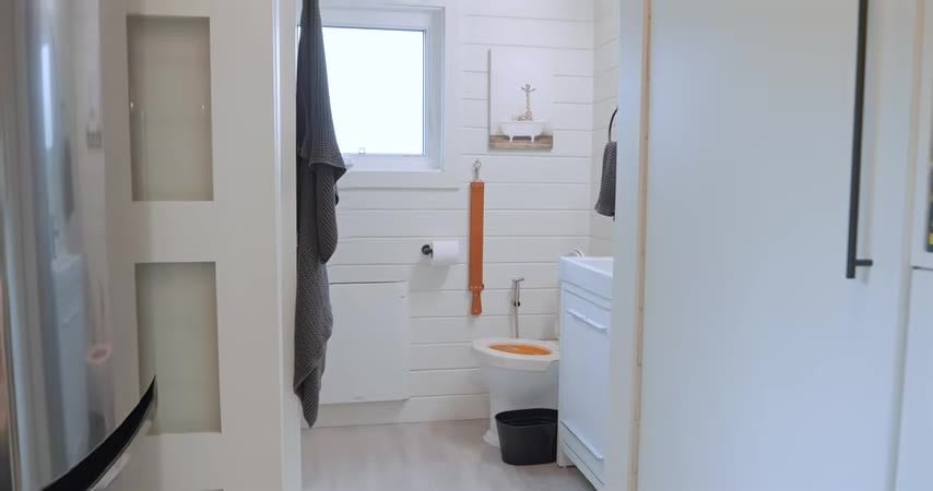 Bathroom with a toilet, sink, and small window
