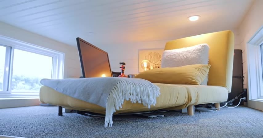 Flex loft with a yellow chair, window, and carpet