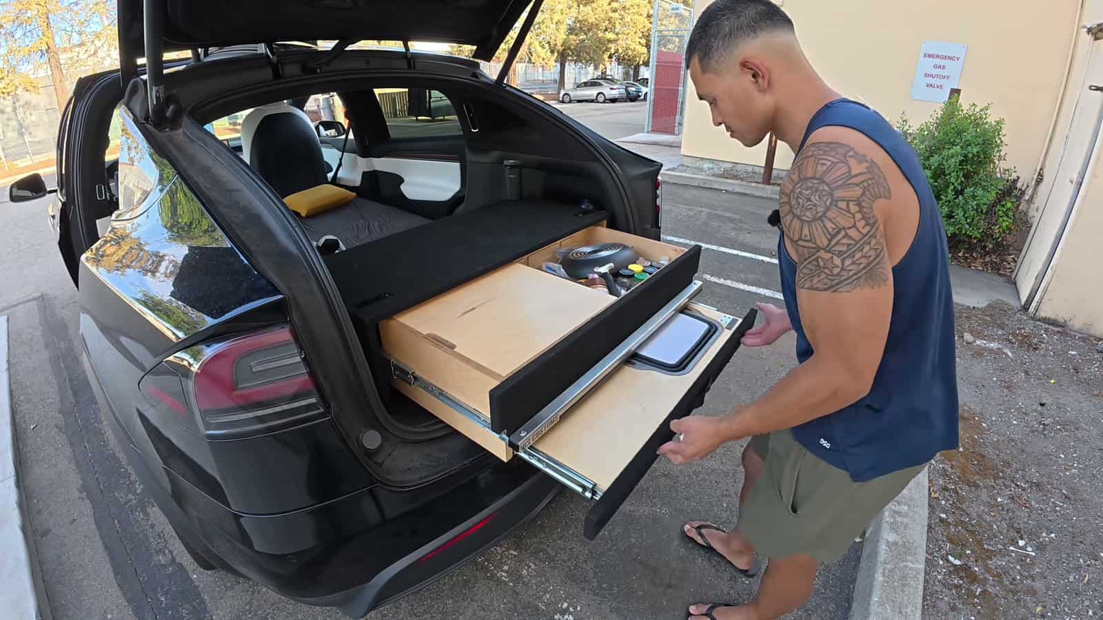 Nico Murillo pulling out the slide-out kitchen drawer of his Tesla Model X camper