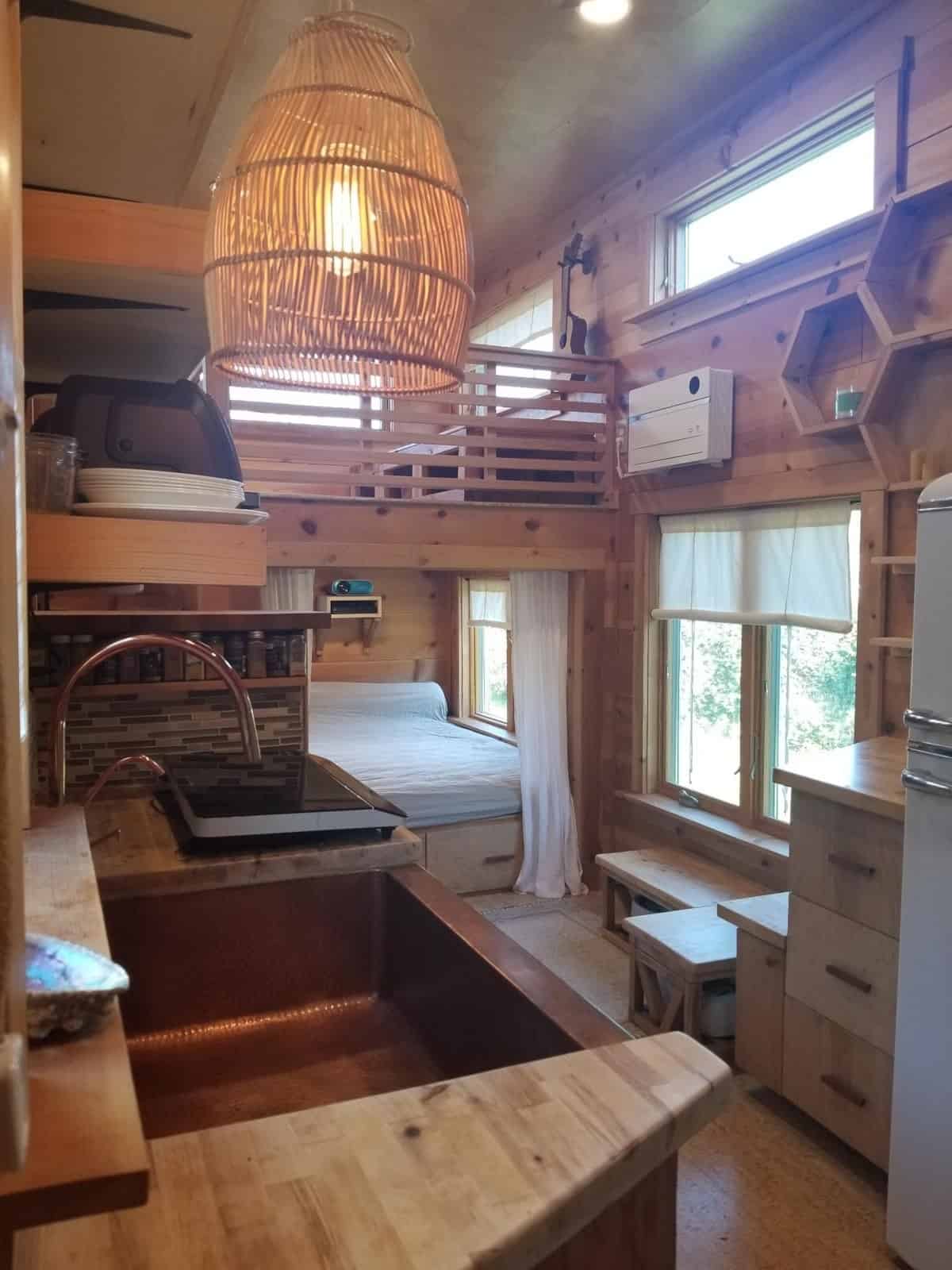 View down the length of the tiny house from the kitchen toward the sleeping loft