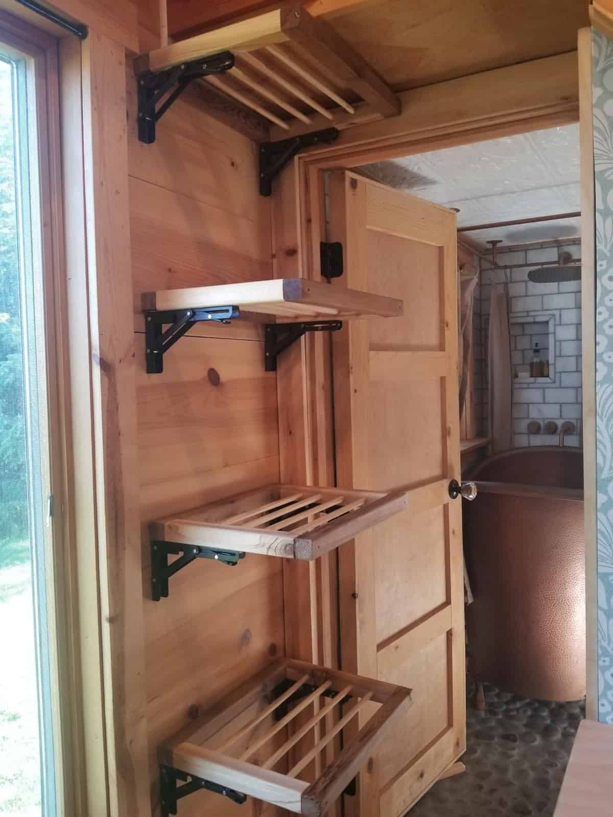 Collapsible wall-mounted laundry drying racks inside the tiny house