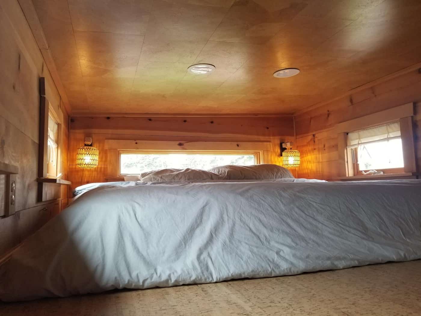 Second sleeping loft under a pine ceiling with a window