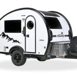 White 2026 nuCamp TAB 320 Boondock Edition teardrop, three-quarter studio: porthole door, mountain graphic, diamond-plate tongue box, spare tire