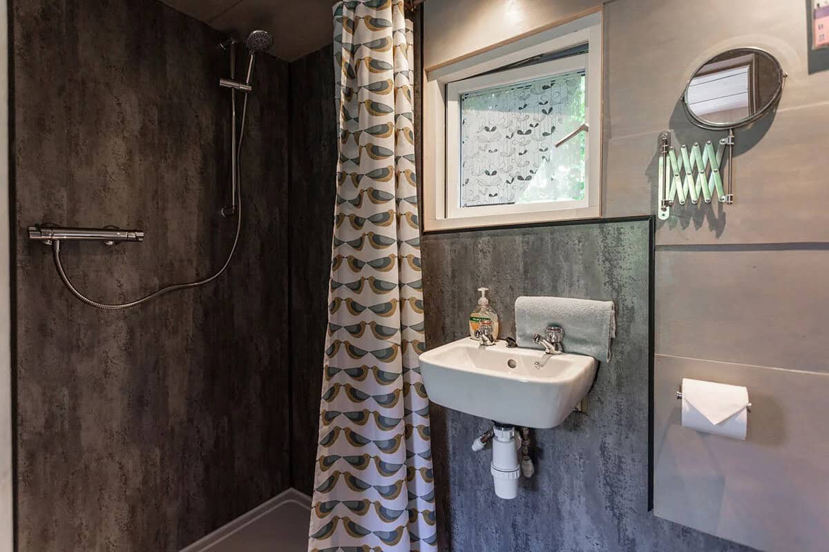 Compact bathroom with hot shower, basin, and loo