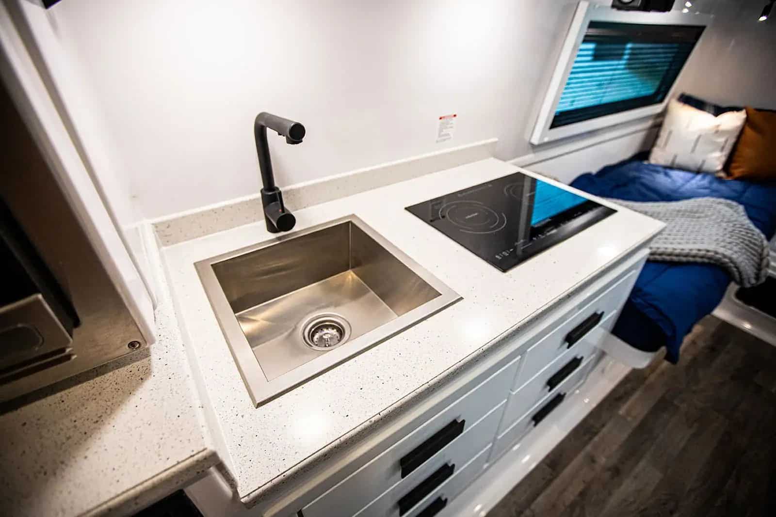 Oliver Legacy Elite II galley close-up: sink, induction cooktop, white drawers