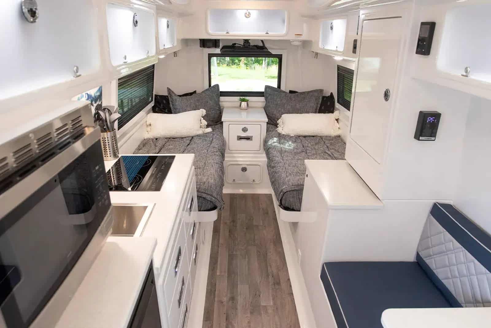 Oliver Legacy Elite II interior: twin beds aft, galley with sink and cooktop, seating, white fiberglass cabinetry