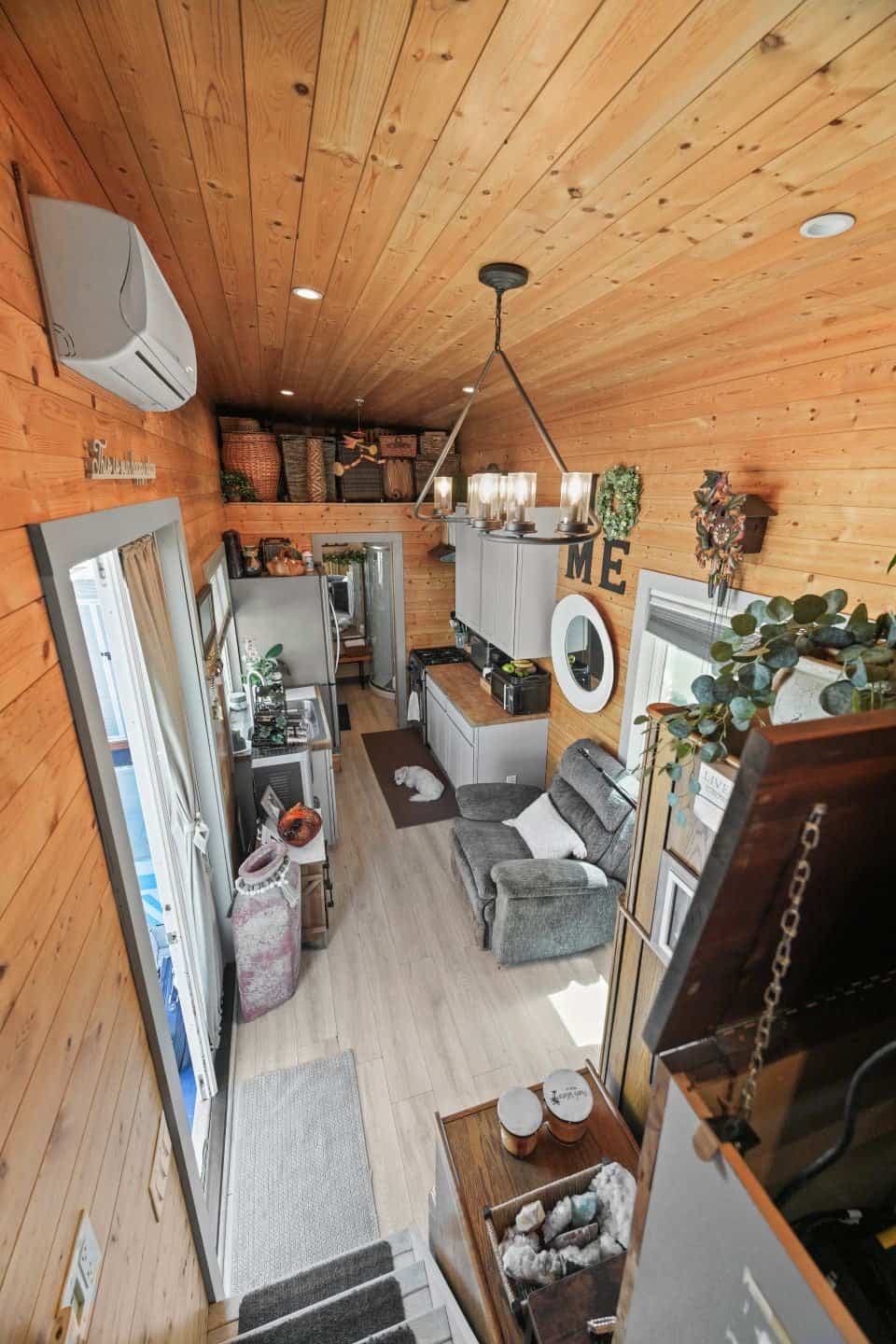 View down the length of the Oxnard tiny house from the bedroom stairs toward the kitchen and bathroom