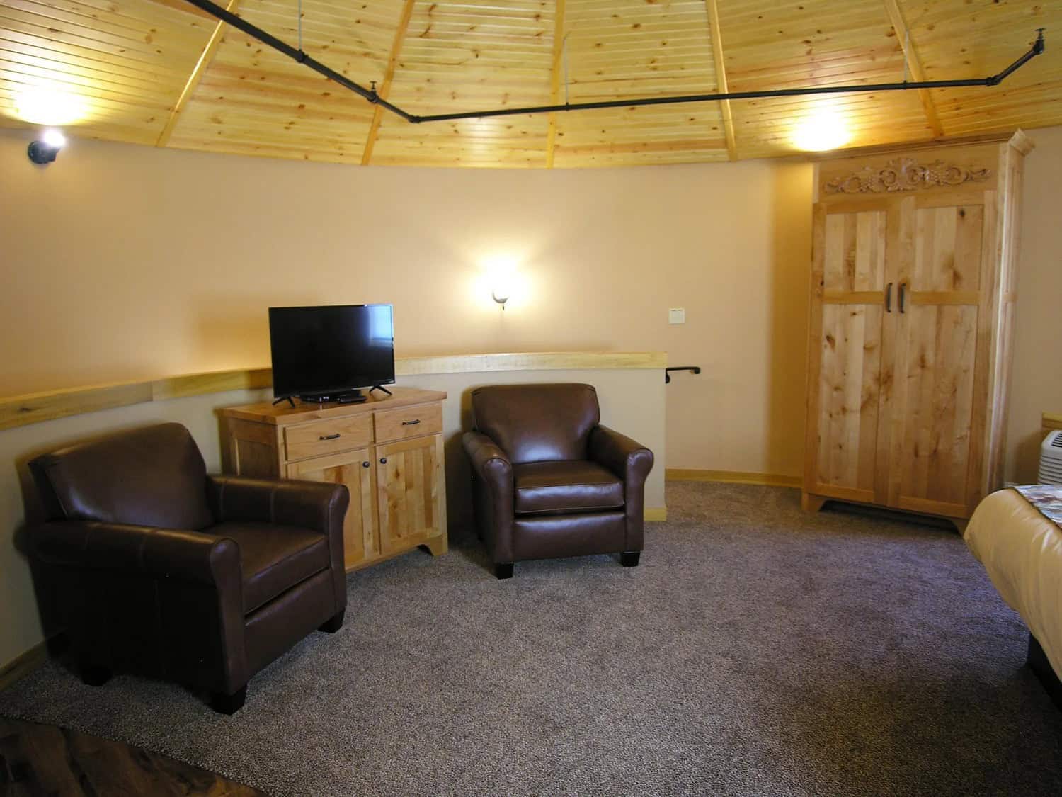 Upstairs sitting area with chairs near the king bed in a Patoka Silo Suite