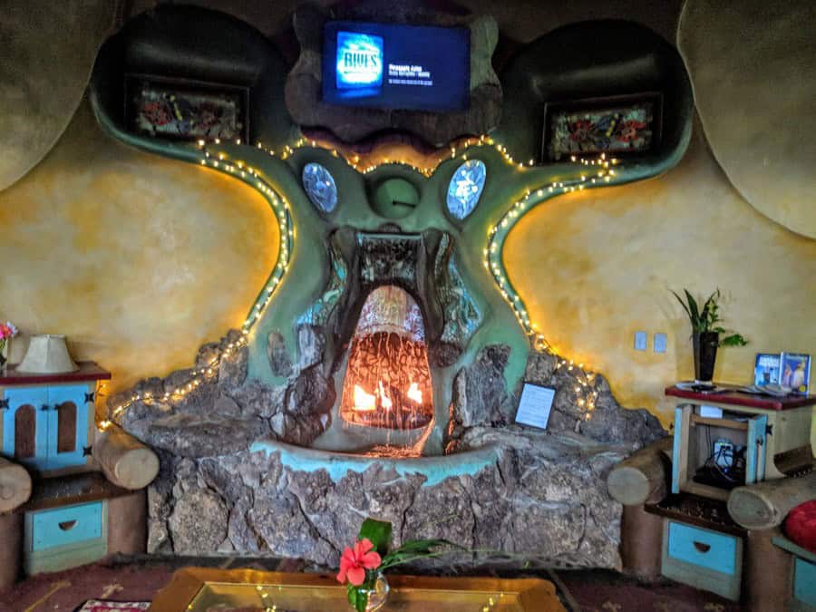 Sculptural fireplace with water over rock and string lights