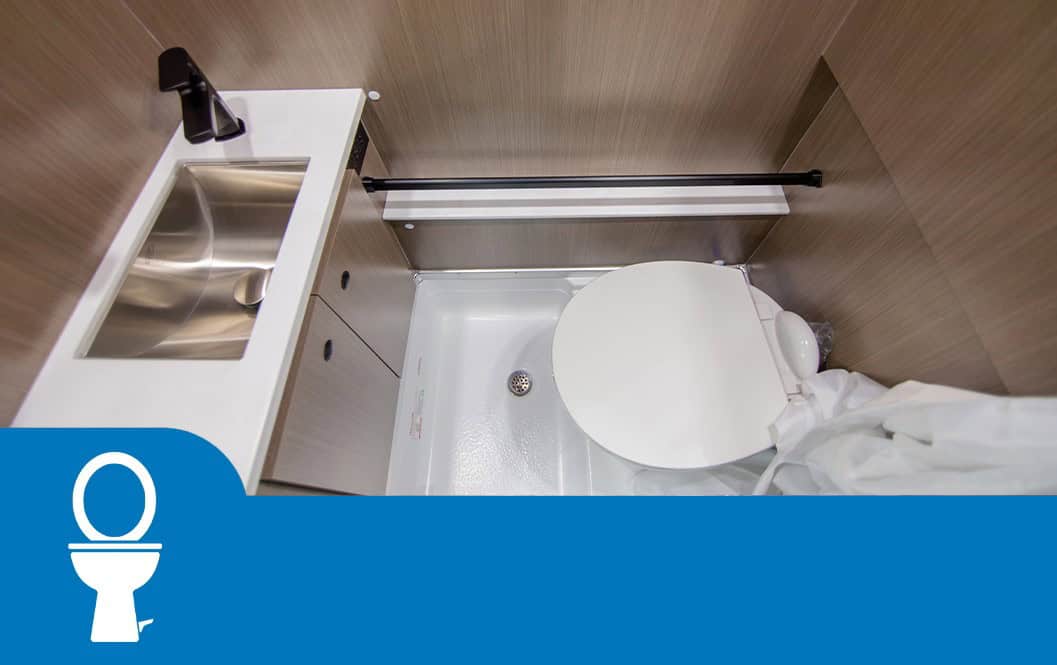 Wet bath with a stainless sink on a solid-surface counter and a china bowl toilet